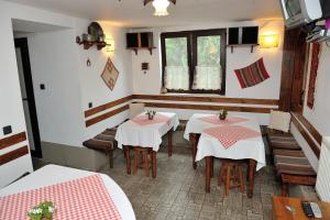a restaurant with two tables and chairs and a window at The House of Petar Levski in Berkovitsa