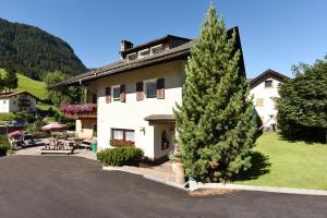 un grande pino di fronte a un edificio di Hotel Garni Vanadis a Ortisei