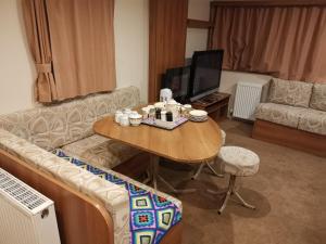 a living room with a couch and a table at Caledonian Caravan in Jaywick Sands