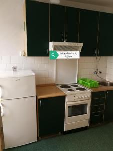 a kitchen with a white stove and a white refrigerator at Stan na dan Apartman 31 in Užice