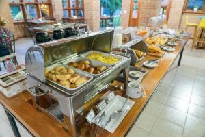 a buffet line with various types of pastries and food at Pousada Girassol in Bonito +131 photos