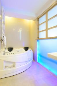 a bathroom with a tub and a window at Hotel Christina Plus in Bucharest