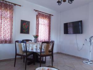 a dining room with a table and chairs and a tv at Hristos house in Toroni