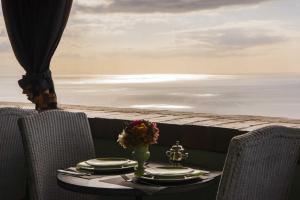 a table with chairs and a table with a view of the ocean at Hotel Villa Carlotta in Taormina