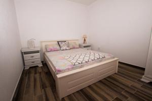 1 dormitorio con 1 cama y 2 mesitas de noche en Banjo Rustic House Lake view en Virpazar