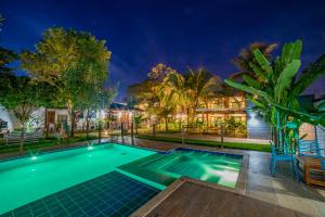 a swimming pool in the backyard of a house at night at Pousada Girassol in Bonito