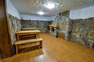 a stone room with benches and a stone fireplace at Dom Gościnny BIERWIONO in Cisna