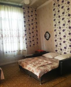 um quarto com uma cama com papel de parede floral em Guest House Knarik em Jvari
