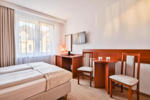 a hotel room with a bed and a table and chair at Rancho Willa & Restaurant in Rewal