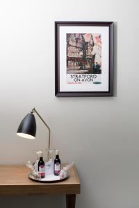 un’immagine su un muro sopra un tavolo con una lampada di The Angel Hotel a Leamington Spa