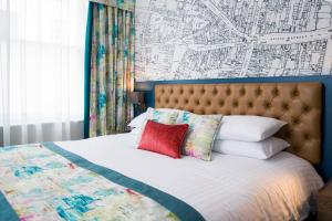 a bedroom with a bed with a map on the wall at The Angel Hotel in Leamington Spa