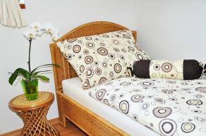 Cama de mimbre con almohada y jarrón con flores en Ekofarma Horní Chrášťany, en Lhenice