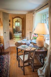 a living room with a table with a vase on it at Milton Farm in East Knoyle