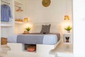 una camera bianca con un letto di Thea Suites Naxos ad Agios Prokopios