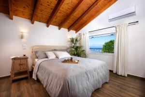 a bedroom with a bed and a large window at Corfu Seaview Maisonette - Sopra il Mare in Petrití