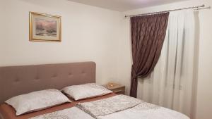 a bed with two pillows on it in a bedroom at Apartments Antolović in Vrsar
