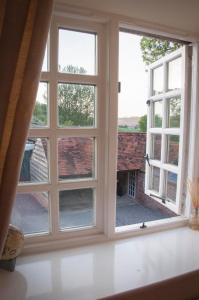 an open window with a view of a courtyard at Milton Farm in East Knoyle
