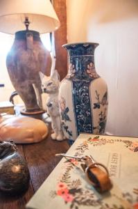 une table avec un vase et un chat dessus dans l'établissement Milton Farm, à East Knoyle