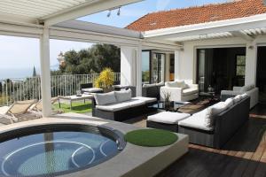 a patio with a hot tub and furniture on a deck at Rooftop grande terrasse jacuzzi vue mer in Cannes