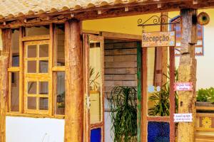 a door to a building with a sign on it at Pousada Luz do Sol in Carrancas