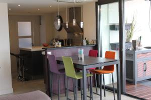 a kitchen with a black table and colorful chairs at Rooftop grande terrasse jacuzzi vue mer in Cannes