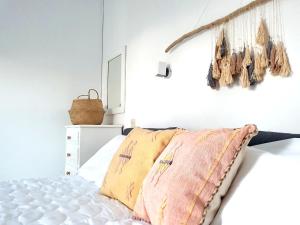 una camera con un letto e un ramo sul muro di Greekowl apartments a Città di Skiathos