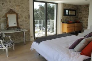 een slaapkamer met een bed en een tafel en een balkon bij Rooftop grande terrasse jacuzzi vue mer in Cannes