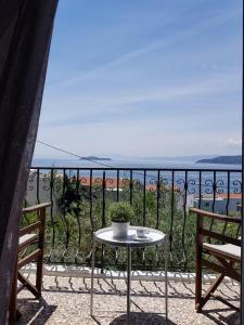 un tavolo su un balcone con vista sull'oceano di Greekowl apartments a Città di Skiathos