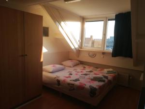 a small bedroom with a bed and a window at Bed & Breakfast Vlissingen in Vlissingen