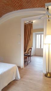 1 dormitorio con 1 cama, mesa y sillas en Palazzo Colombino Suite&Residence, en Giaveno
