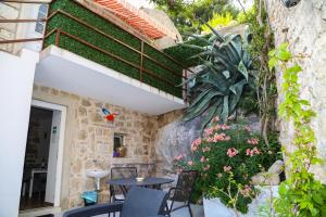 un patio con mesa, sillas y flores en Apartments Seka, en Hvar