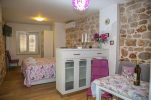 a small bedroom with a bed and a table with a table at Apartments Seka in Hvar