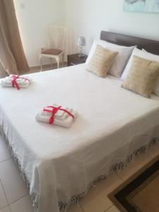 a large white bed with two white towels on it at White Pearl Apart 5 in Marsaxlokk