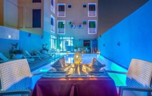 a dining room with a table and chairs and a pool at Rose Valley Hotel in Ouarzazate