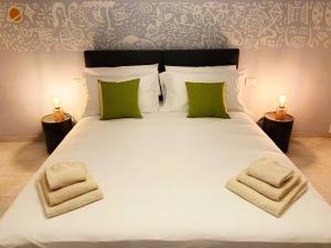sypialnia z dużym białym łóżkiem z zielonymi poduszkami w obiekcie House of Arts w mieście Montelupo Fiorentino