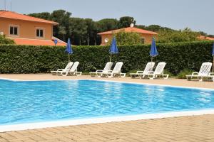 una piscina con tumbonas y sombrillas en Portoada Park Villas, en Pizzo