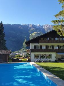 une maison avec une piscine en face d'un bâtiment dans l'établissement Pension Lärchenhof, à Naturno