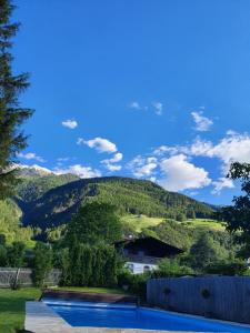 a swimming pool with a mountain in the background at Pension Lärchenhof in Naturno