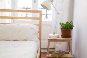 リスボンにあるCaraujo Apartmentsのベッドルーム1室(ベッド1台、ランプと植物付きのデスク付)