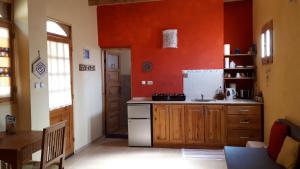 cocina con paredes de color naranja y nevera blanca en Think Love on Red Sea, en Nuweiba