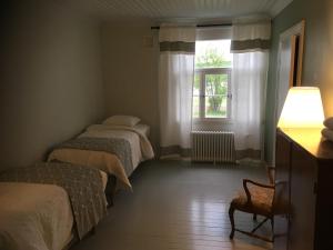 
a bedroom with two beds and a window at Guesthouse Kumpunen in Petäjävesi
