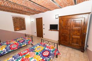 una camera con due letti e una tv di OstellOrto a San Martino Canavese