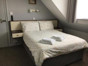 1 dormitorio con 1 cama con toallas en Avoca Villa Guest House, en Saint Helier Jersey