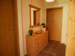 a bathroom with a wooden dresser with a mirror on it at Ferienwohnung Wusterwitz in Wusterwitz