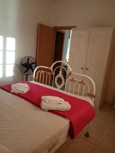 a bedroom with a bed with a red blanket at Kokagia House in Cherronisos