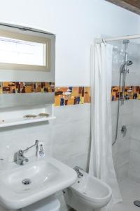 bagno bianco con lavandino e doccia di La Casa di Santino a Comacchio