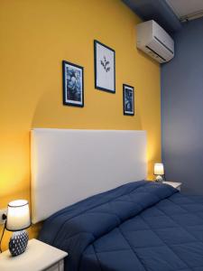 a bedroom with a blue bed and a yellow wall at B&B L'Edera di Caterina in Reggio di Calabria