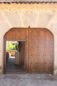 eine Holztür in einem Gebäude mit einem Hund dahinter. in der Unterkunft Santamaría - Mirador de Pedraza in Pedraza