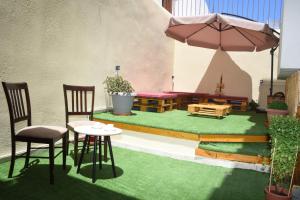 a patio with a table and chairs and an umbrella at Little Yard Studios & Apartments #3 in Naxos Chora