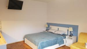 ein Schlafzimmer mit einem großen Bett mit einer blauen Decke in der Unterkunft Apartma Lahinja in Gradac